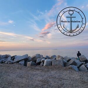 Scenic Ocean View with Rocks and Fisherman